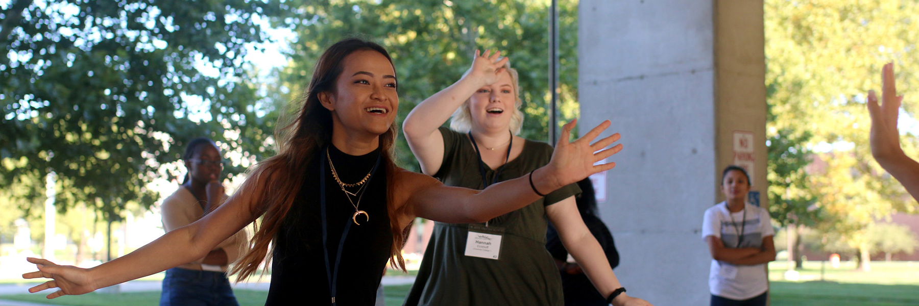 Students smiling with their arms raised