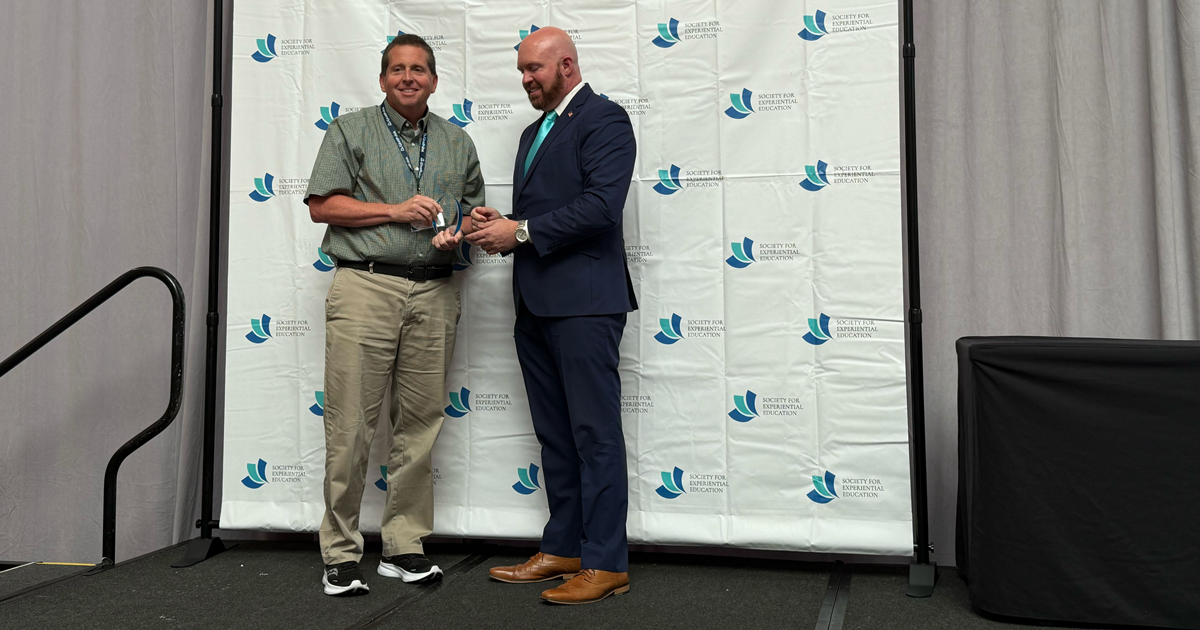 Jerry Daday accepting an award from someone.